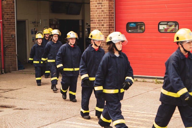 fire service personel unrolling a hose